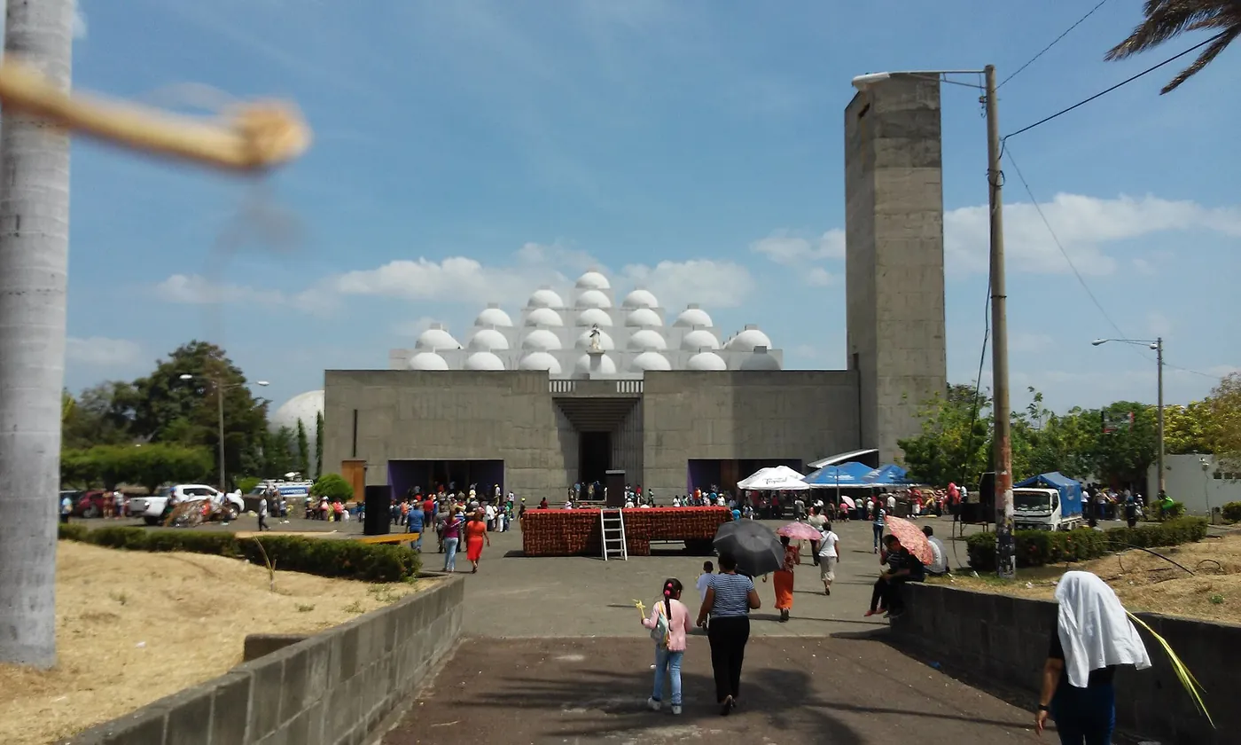 A modern concrete cathedral with a roof of many small domes
